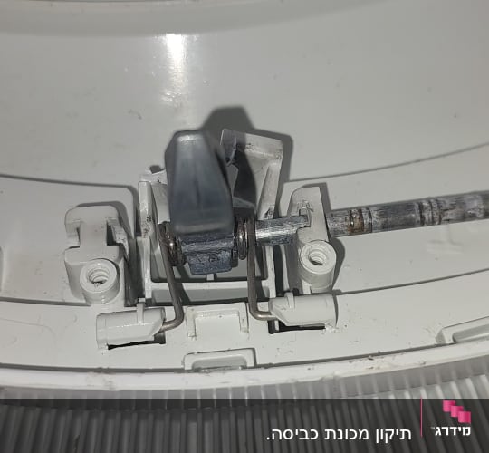 חלק מתכת מחובר למנגנון פלסטיק במכשיר חשמלי